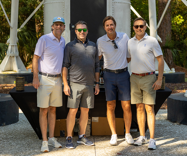 Golfers pose for a quick photo beneath one of Hilton Head Island’s oldest lighthouses